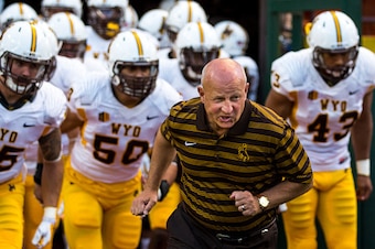 HONOLULU, HI - OCTOBER 11: Craig Bohl head coach of the Wyoming Cowboys and the team take to the field before the first quarter of a college football game between the Wyoming Cowboys and the Hawaii Warriors at Hawaiian Airlines Field at Aloha Stadium on O