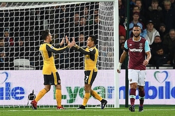 Arsenal's German midfielder Mesut Ozil (L) celebrates with Arsenal's Chilean striker Alexis Sanchez after scoring the opening goal of the English Premier League football match between West Ham United and Arsenal at The London Stadium, in east London on De