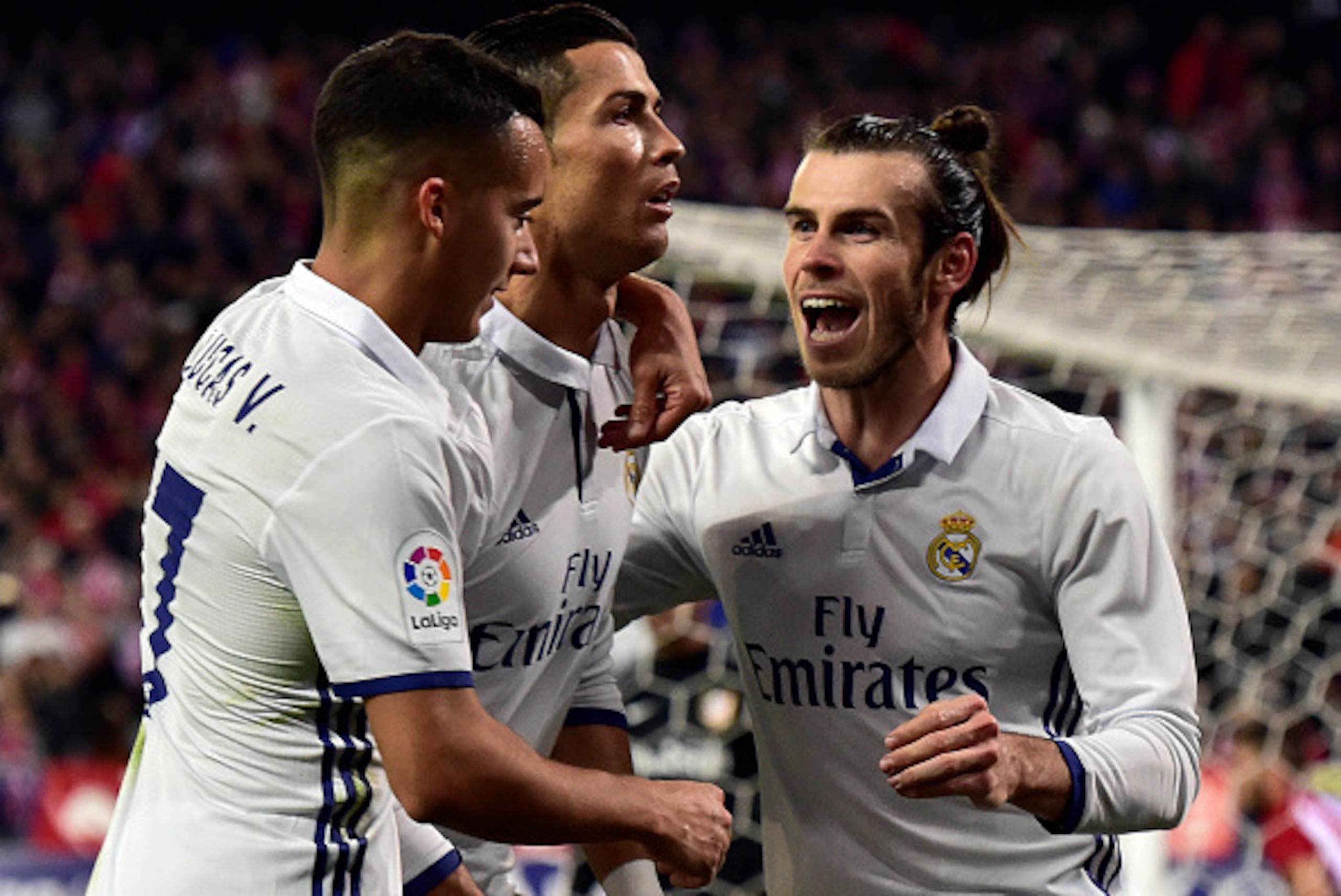 Real Madrid's Portuguese forward Cristiano Ronaldo (C) celebrates a goal with Real Madrid's midfielder Lucas Vazquez (L) and Real Madrid's Welsh forward Gareth Bale during the Spanish league football match between Club Atletico de Madrid and Real Madrid C