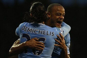 Manchester City's Belgian defender Vincent Kompany (R) celebrates with Manchester City's Argentinian defender Martin Demichelis (L) after scoring his team's second goal during the English Premier League football match between Fulham and Manchester City at