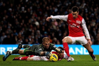 MANCHESTER, ENGLAND - DECEMBER 18:   Joe Hart of Manchester City dives to make a save at the feet of Laurent Koscielny of Arsenal during the Barclays Premier League match between Manchester City and Arsenal at the Etihad Stadium on December 18, 2011 in Ma