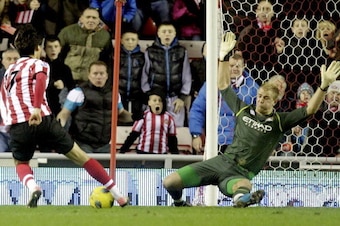 Sunderland's South Korean striker, Ji Dong-Won (L) goes around Manchester City's Joe Hart (R) to score the winning goal during an English FA Premier League football match at the Stadium of Light, Sunderland, England, on January 1, 2012. AFP PHOTO/GRAHAM S