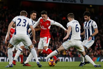 Arsenal's German midfielder Mesut Ozil (C) is surrounded by West Brom players during the English Premier League football match between Arsenal and West Bromwich Albion at the Emirates Stadium in London on December 26, 2016.  / AFP / IAN KINGTON / RESTRICT