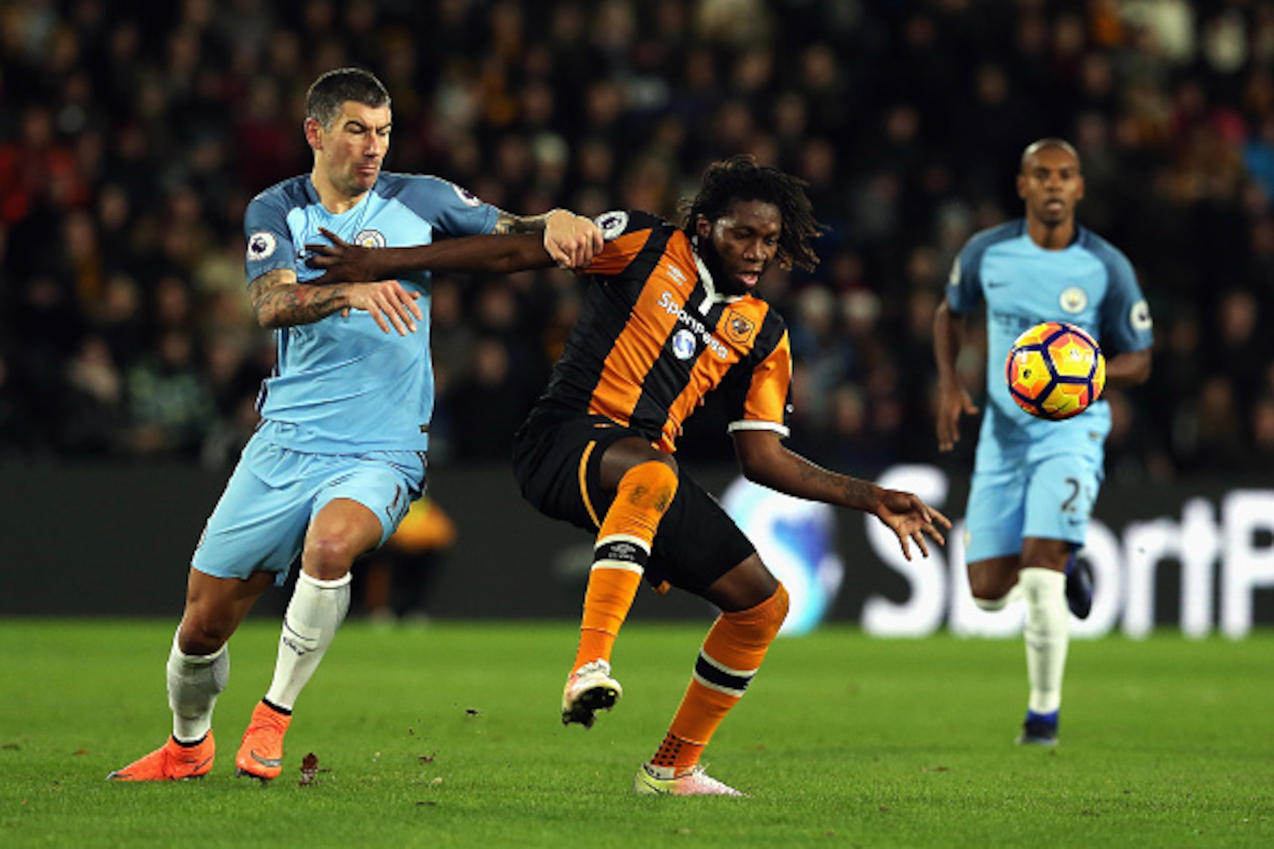 HULL, ENGLAND - DECEMBER 26:  Dieumerci Mbokani of Hull City is challenged by Aleksandar Kolorov of Manchester City during the Premier League match between Hull City and Manchester City at KCOM Stadium on December 26, 2016 in Hull, England.  (Photo by Nig