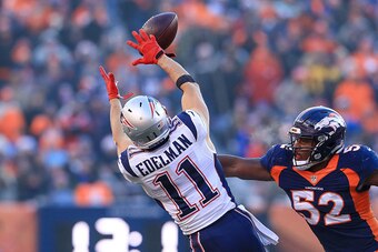 DENVER, CO - DECEMBER 18:  Wide receiver Julian Edelman #11 of the New England Patriots jumps for a reception under coverage by inside linebacker Corey Nelson #52 of the Denver Broncos in the second quarter of a game at Sports Authority Field at Mile High