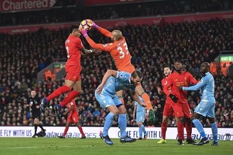 Stoke City's English goalkeeper Lee Grant (2L) claims the ball from the head of Liverpool's English defender Nathaniel Clyne (L) during the English Premier League football match between Liverpool and Stoke City at Anfield in Liverpool, north west England 