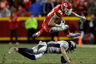KANSAS CITY, MO - DECEMBER 25:  Tight end Travis Kelce #87 of the Kansas City Chiefs leaps over free safety Justin Simmons #31 of the Denver Broncos during the game at Arrowhead Stadium on December 25, 2016 in Kansas City, Missouri.  (Photo by Jamie Squir