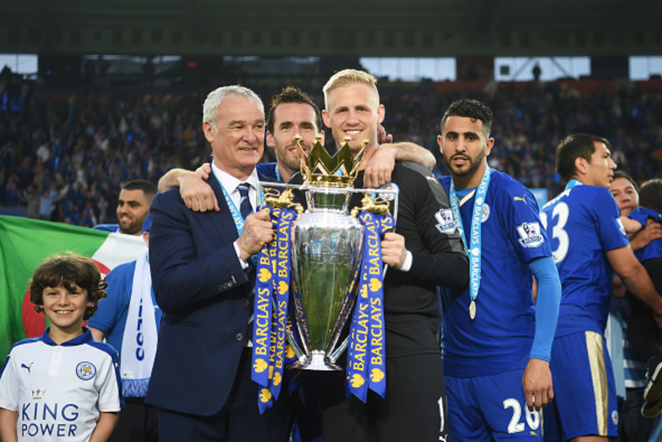 LEICESTER, ENGLAND - MAY 07:  Manager Claudio Ranieri, Christian Fuchs, Kasper Schmeichel and Riyad Mahrez of Leicester City pose with the Premier League Trophy as players and staffs celebrate the season champions after the Barclays Premier League match b