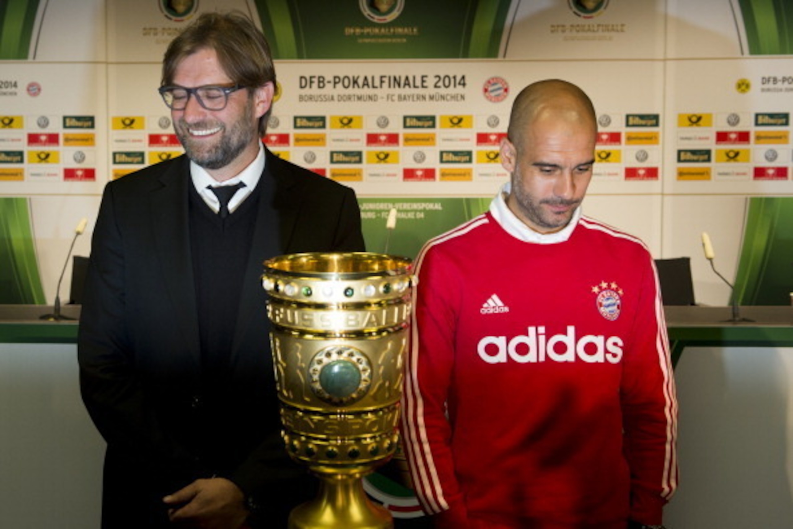 Bayern Munich's Spanish head coach Pep Guardiola (R) and Dortmund's head coach Juergen Klopp pose with the trophy after a press conference at Berlin's Olympic Stadium on May 16, 2014 on the eve of the German Cup Football final BVB Dortmund vs Bayern Munic
