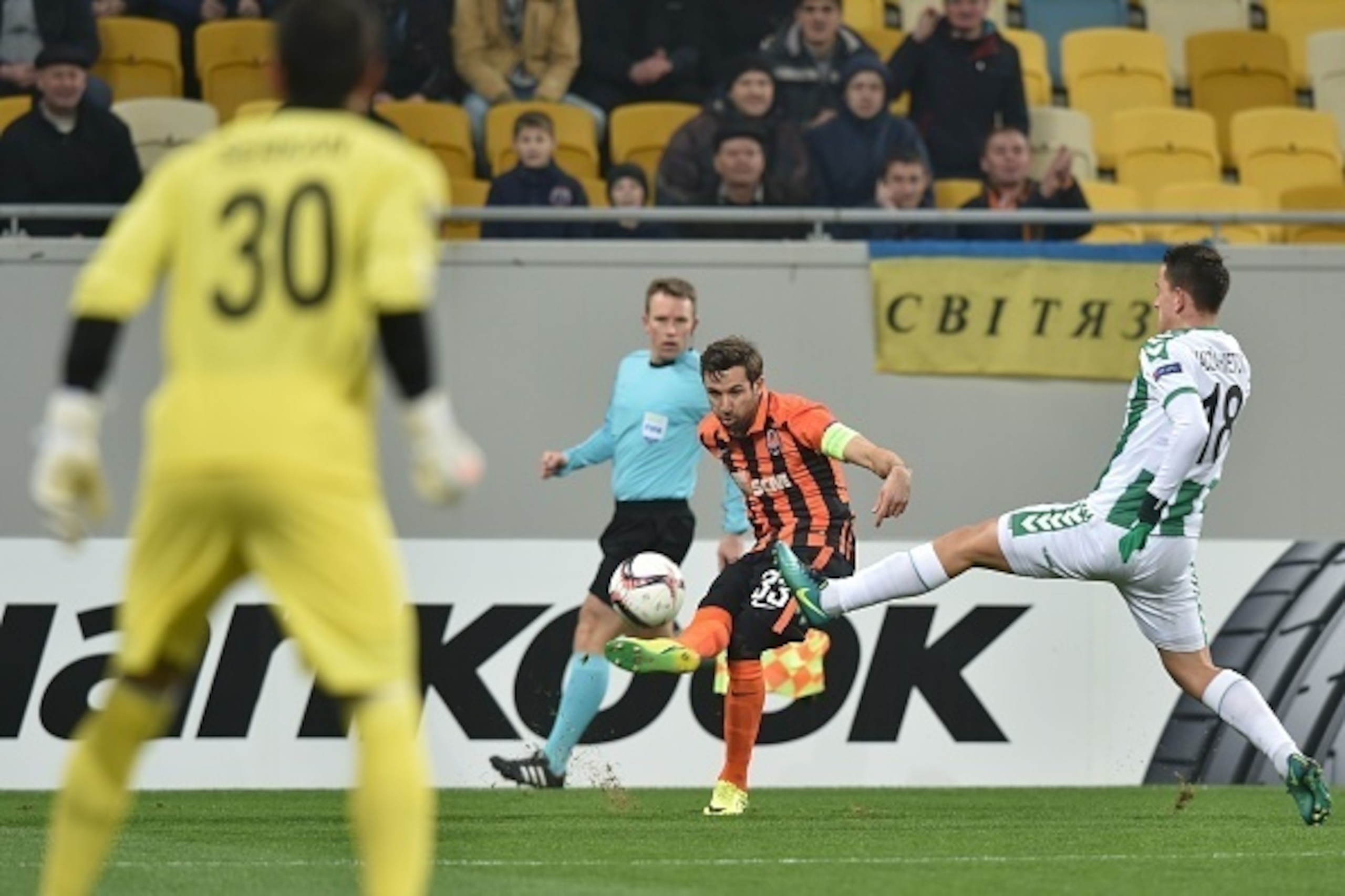 FC Shakhtar's Croatian defender Darijo Srna(C) and Konyaspor's Bosnian midfielder Amir Hadziahmetovic (R) vie for the ball during the UEFA Europa League Group H football match between FC Shakhtar Donetsk and Konyaspor at the Arena Lviv stadium in Lviv, on