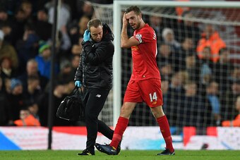 Liverpool's English midfielder Jordan Henderson (R) leaves the pitch after appearing to pick up an injury during the English Premier League football match between Liverpool and Manchester City at Anfield in Liverpool, north west England on December 31, 20