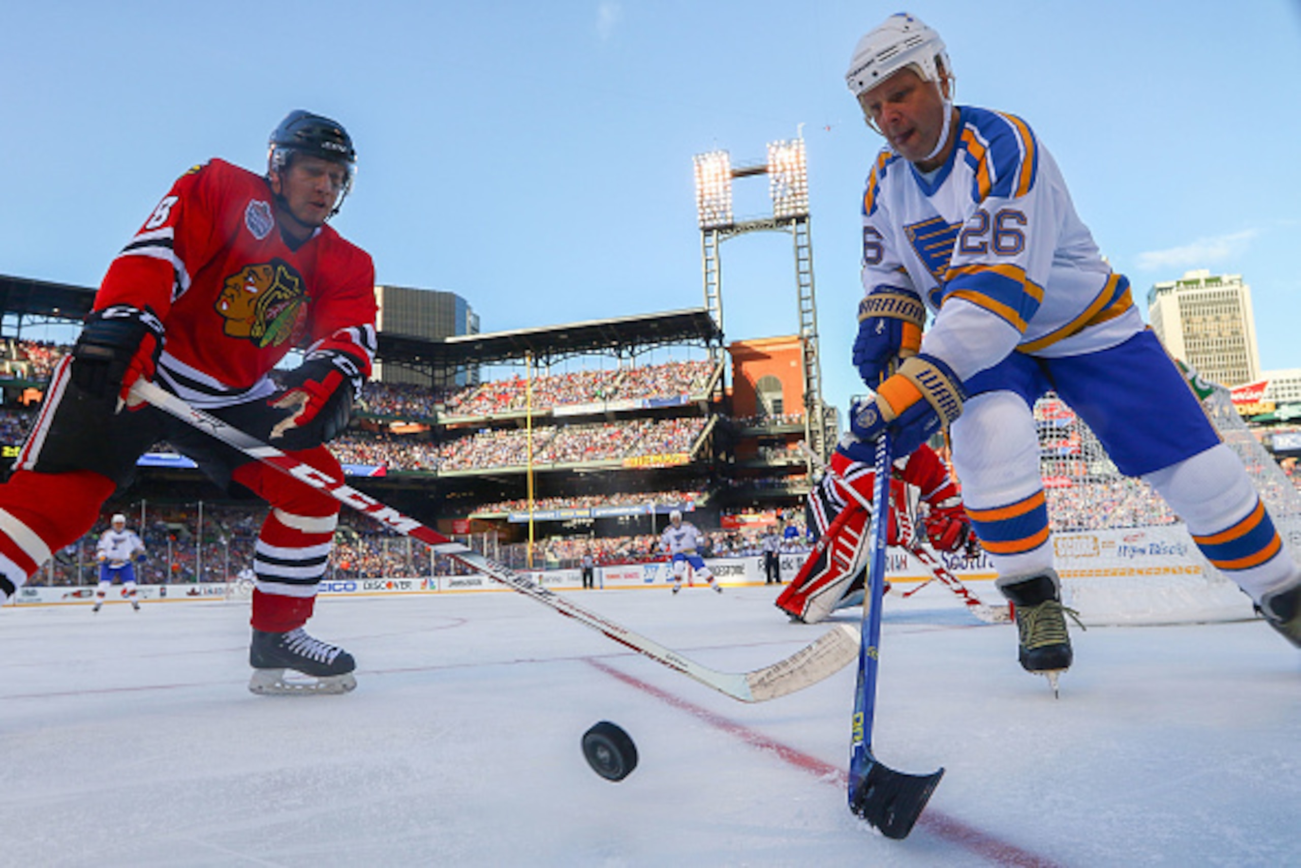 ST. LOUIS, MO - DECEMBER 31: Steve Poapst #8 of the Chicago Blackhawks and Peter Stastny #26 of the St. Louis Blues chase the puck during the 2017 NHL Winter Classic Alumni Game at Busch Stadium on December 31, 2016 in St. Louis, Missouri.  (Photo by Dili