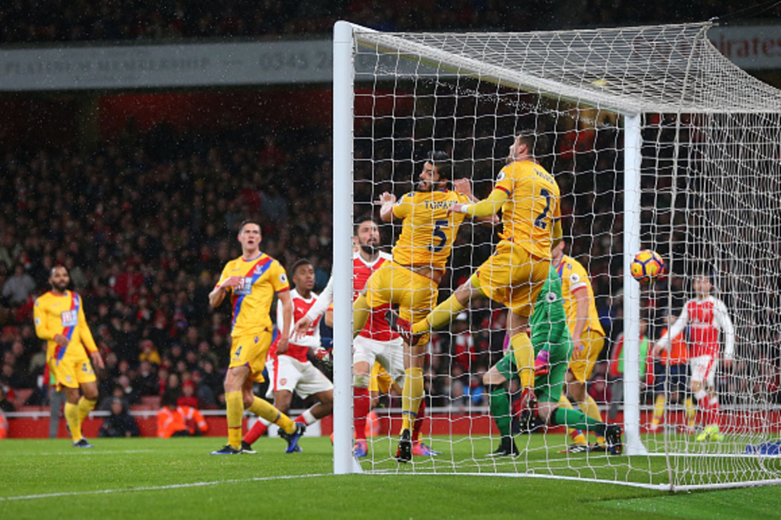 LONDON, ENGLAND - JANUARY 01: James Tomkins and Joel Ward of Crystal Palace are unable to stop the shot from Alex Iwobi of Arsenal who scores a goal to make it 2-0 during the Premier League match between Arsenal and Crystal Palace at Emirates Stadium on J