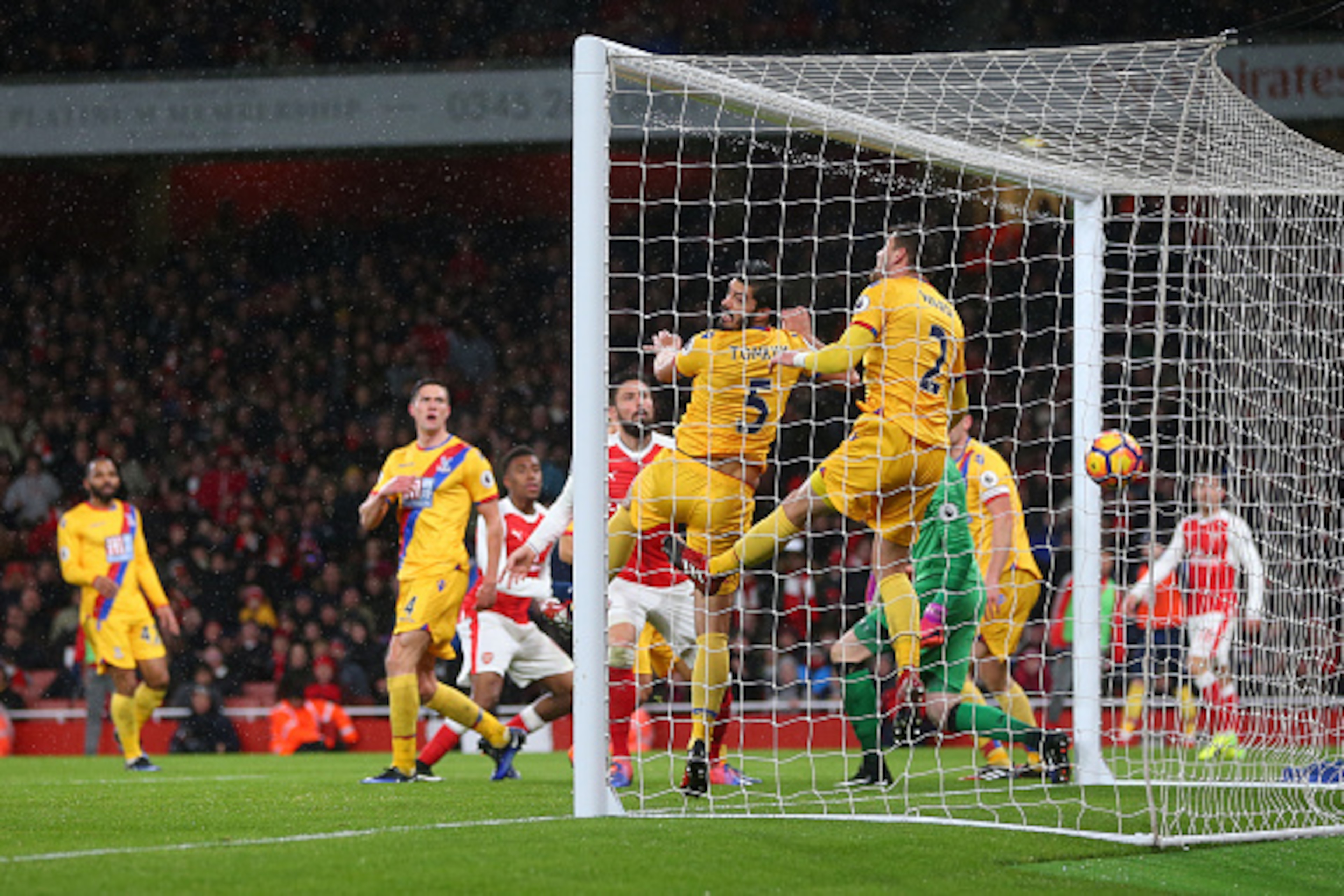 LONDON, ENGLAND - JANUARY 01: James Tomkins and Joel Ward of Crystal Palace are unable to stop the shot from Alex Iwobi of Arsenal who scores a goal to make it 2-0 during the Premier League match between Arsenal and Crystal Palace at Emirates Stadium on J