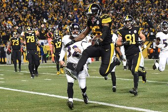 PITTSBURGH, PA - DECEMBER 25:  Le'Veon Bell #26 of the Pittsburgh Steelers leaps into the end zone in front of Eric Weddle #32 of the Baltimore Ravens for a 7 yard rushing touchdown in the fourth quarter during the game at Heinz Field on December 25, 2016
