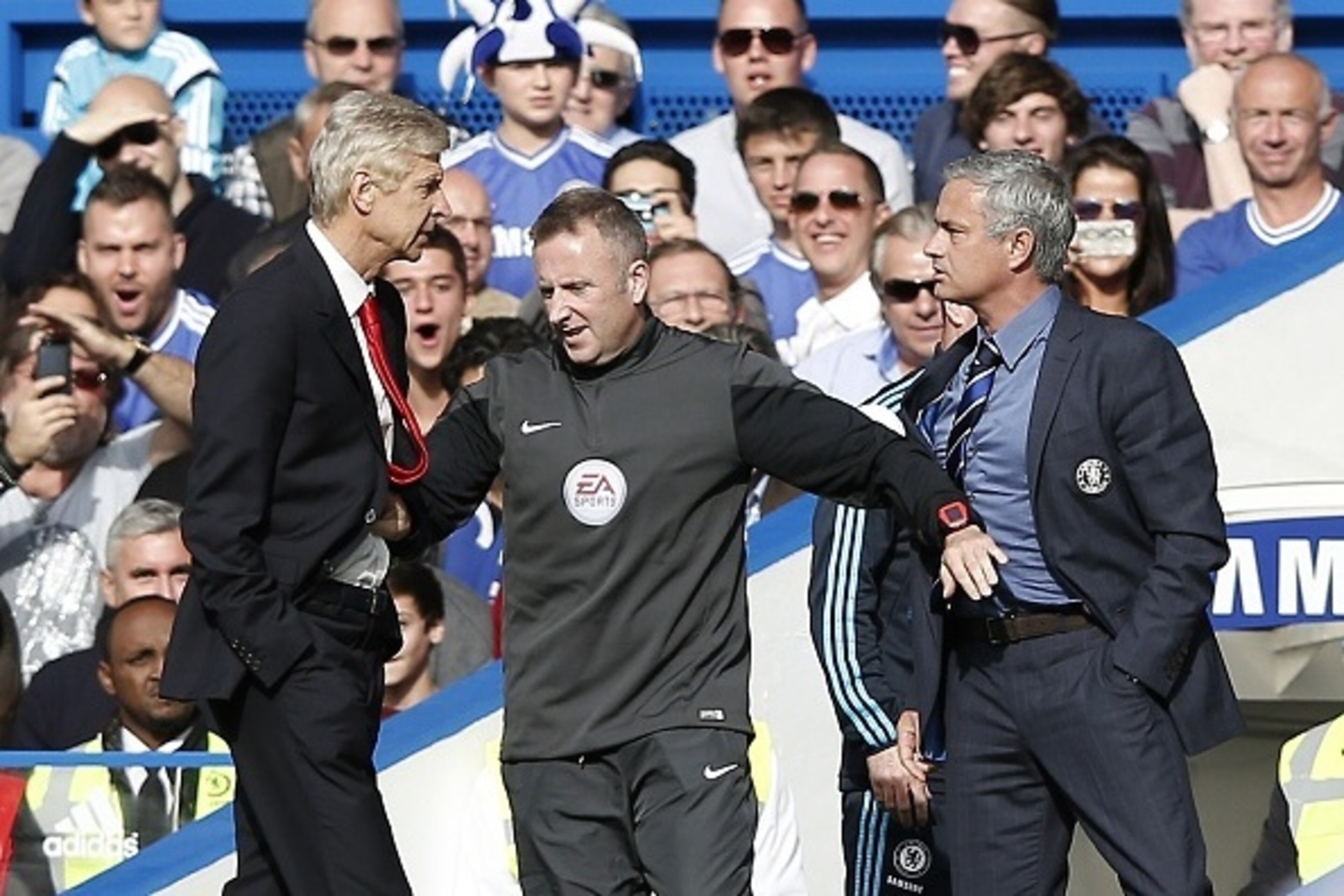Chelsea's Portuguese manager Jose Mourinho (R) and Arsenal's French manager Arsene Wenger (L) are kept apart by the fourth official Jonathan Moss during the English Premier League football match between Chelsea and Arsenal at Stamford Bridge in London on Chelsea's Portuguese manager Jose Mourinho (R) and Arsenal's French manager Arsene Wenger (L) are kept apart by the fourth official Jonathan Moss during the English Premier League football match between Chelsea and Arsenal at Stamford Bridge in London on