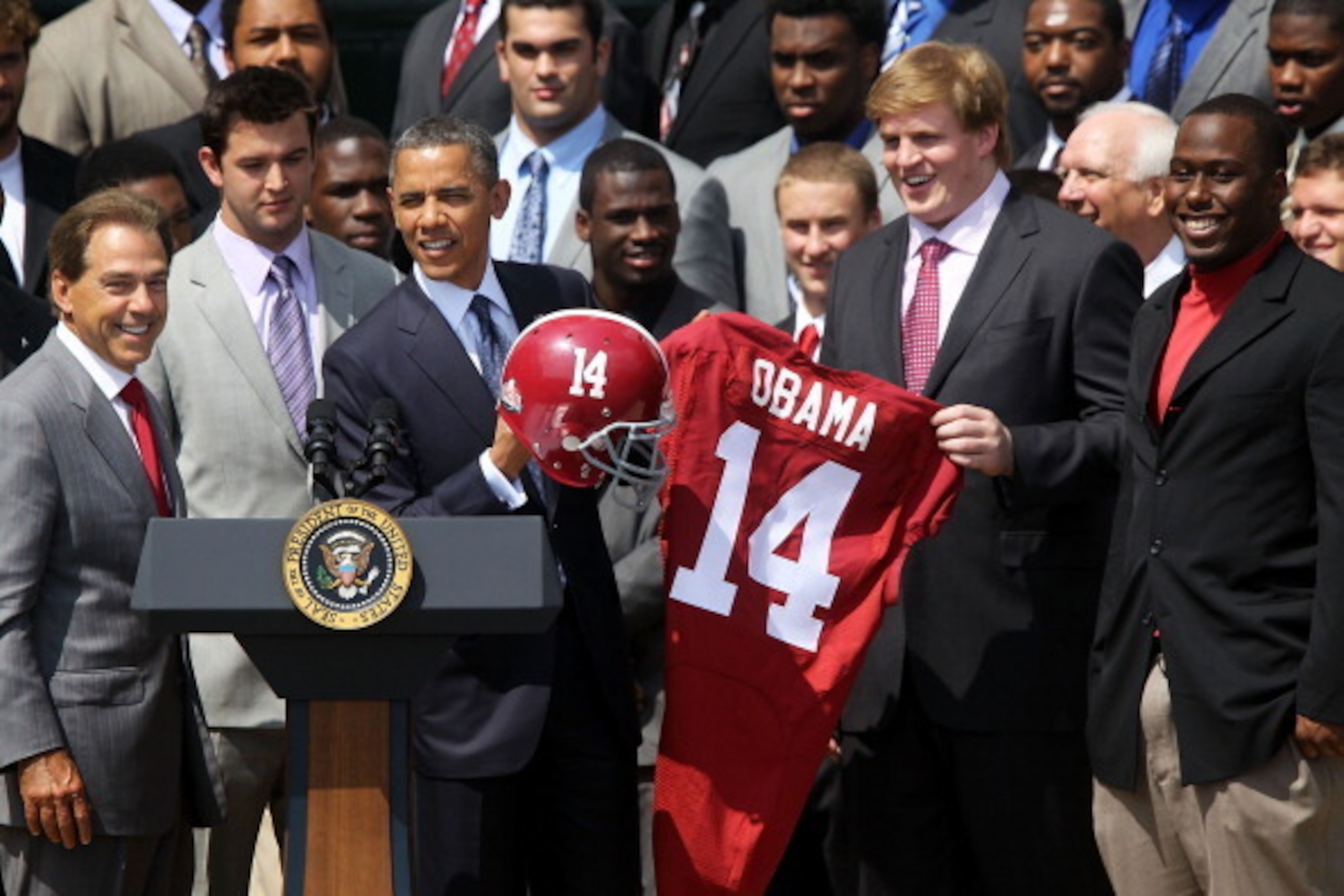 WASHINGTON, DC - APRIL 19: U.S. President Barack Obama is presented with a jersey and a helmet by defensive lineman Damion Square (R), quarterback A.J. McCarron (2nd L) and offensive lineman Barrett Jones (2nd R) of the University of Alabama Crimson Tide WASHINGTON, DC - APRIL 19: U.S. President Barack Obama is presented with a jersey and a helmet by defensive lineman Damion Square (R), quarterback A.J. McCarron (2nd L) and offensive lineman Barrett Jones (2nd R) of the University of Alabama Crimson Tide