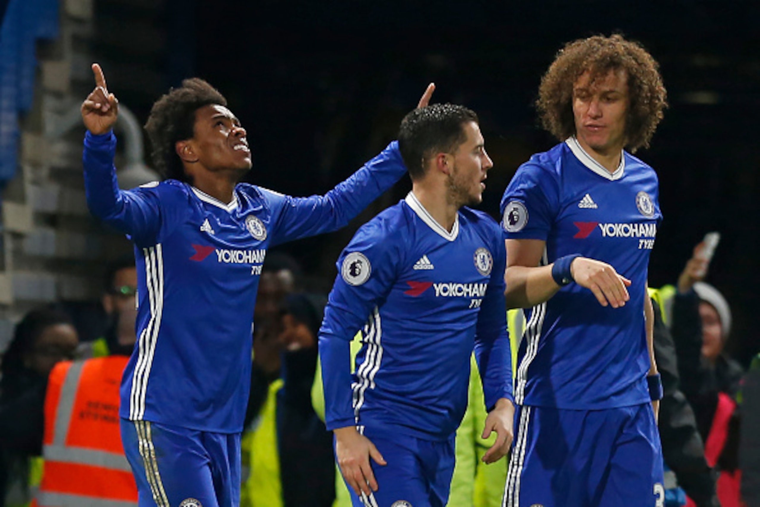 Chelsea's Brazilian midfielder Willian (L) celebrates with teammates after scoring their second goal during the English Premier League football match between Chelsea and Stoke City at Stamford Bridge in London on December 31, 2016. / AFP / Ian KINGTON / R