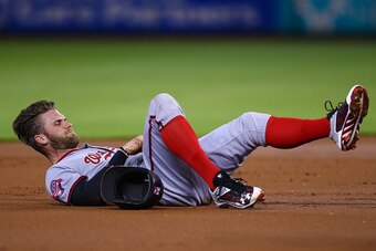 MIAMI, FL - SEPTEMBER 13: Bryce Harper #34 of the Washington Nationals lays injured on the infield after colliding with a Miami Marlins player during the first inning of the game at Marlins Park on September 13, 2015 in Miami, Florida. Harper was taken ou