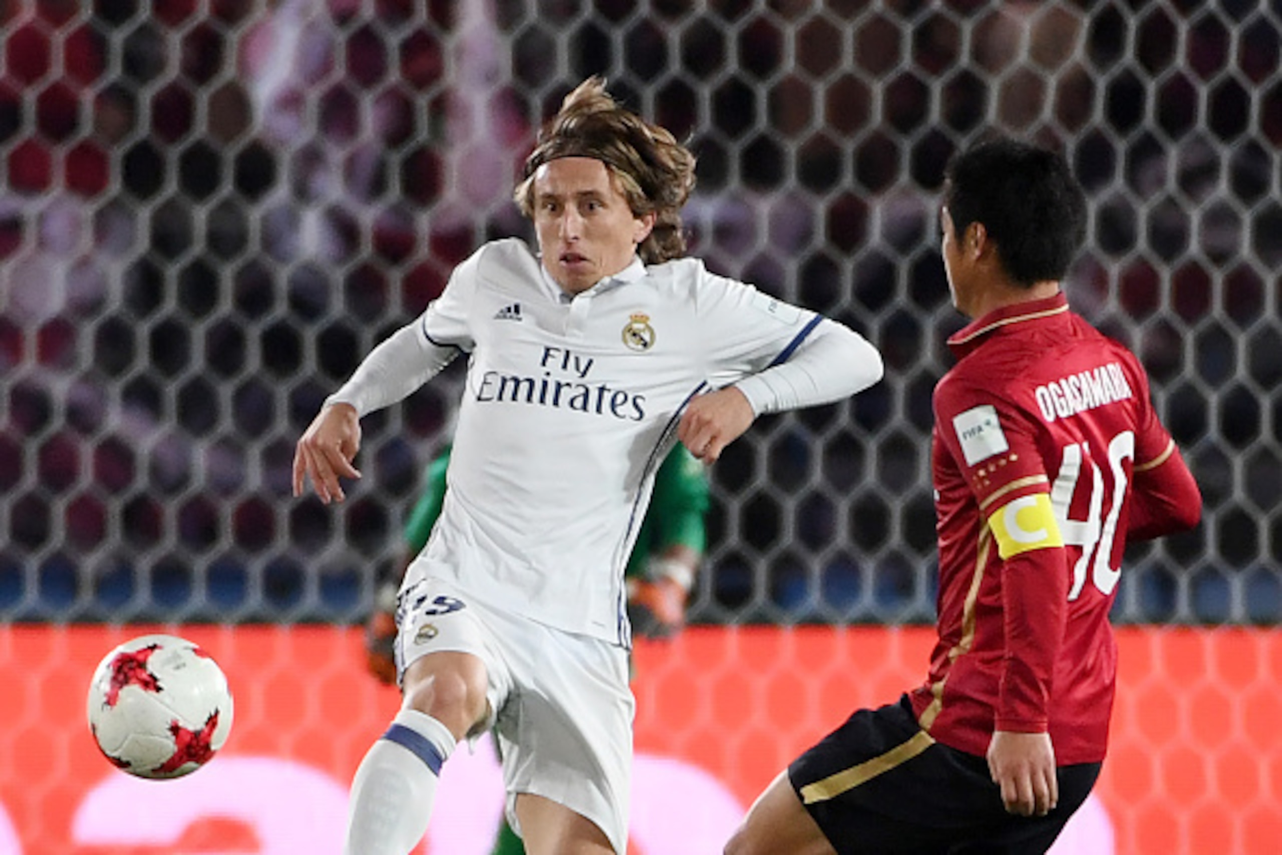 Real Madrid midfielder Luka Modric (L) fights for the ball with Kashima Antlers midfielder Mitsuo Ogasawara during the Club World Cup football final match between Kashima Antlers of Japan and Real Madrid of Spain at Yokohama International stadium in Yokoh Real Madrid midfielder Luka Modric (L) fights for the ball with Kashima Antlers midfielder Mitsuo Ogasawara during the Club World Cup football final match between Kashima Antlers of Japan and Real Madrid of Spain at Yokohama International stadium in Yokoh