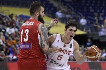 Turkey's Cedi Osman (R) is blocked by Serbia's Miroslav Raduljica during the EuroBasket group B qualification basketball match between Turkey and Serbia in Berlin on September 9, 2015. AFP PHOTO / TOBIAS SCHWARZ        (Photo credit should read TOBIAS SCH