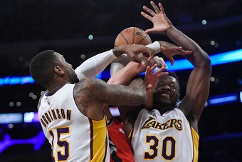 LOS ANGELES, CA - JANUARY 01: Jonas Valanciunas #17 of the Toronto Raptors is sandwiched between Thomas Robinson #15 and Julius Randle #30 of the Los Angeles Lakers during the second half of the basketball game at Staples Center January 1 2017, in Los Ang