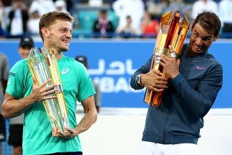 Spain's Rafael Nadal (R) poses with the winners trophy next to Belgium's David Goffin (L) after their final match of the Mubadala World Tennis Championship 2016 in Abu Dhabi on December 31, 2016.
Nadal won 6-4 and 7-6. / AFP / Nezar Balout        (Photo c