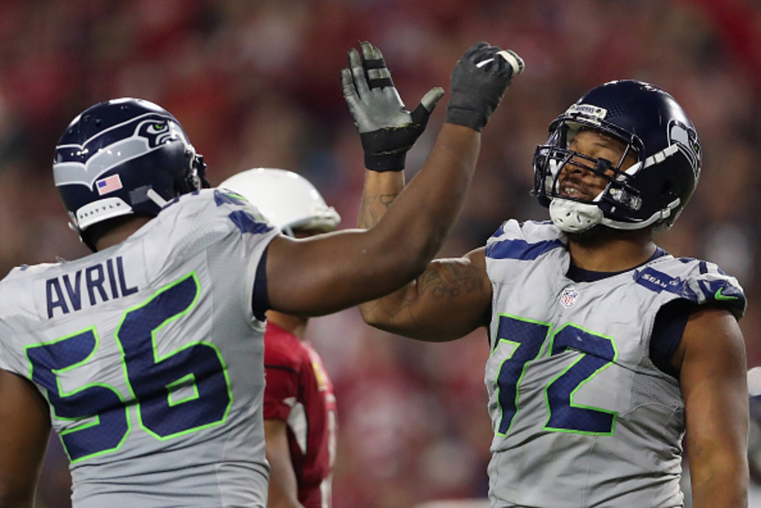 GLENDALE, AZ - OCTOBER 23:  Defensive end Michael Bennett #72 of the Seattle Seahawks high fives Cliff Avril #56 after a defensive stop against the Arizona Cardinals during the second half of the NFL game at the University of Phoenix Stadium on October 23