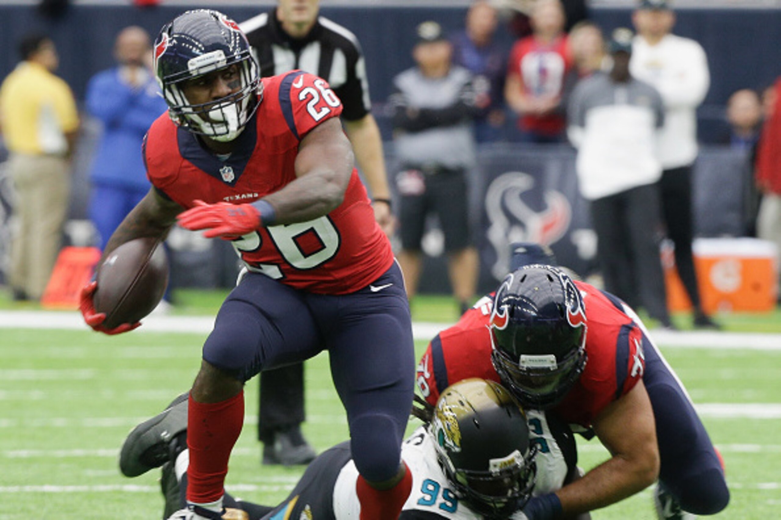 HOUSTON, TX - DECEMBER 18:  Lamar Miller #26 of the Houston Texans breaks a tackle attempt by Sen'Derrick Marks #99 of the Jacksonville Jaguars as Duane Brown #76 blocks on the play at NRG Stadium on December 18, 2016 in Houston, Texas.  (Photo by Bob Lev