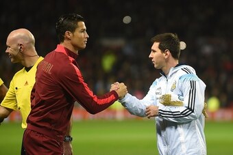 Argentina striker Lionel Messi (R) shakes hands with Portugal's striker Cristiano Ronaldo (L) ahead of kick off of the international friendly football match between the Argentina and Portugal at Old Trafford in Manchester on November 18, 2014. AFP PHOTO /