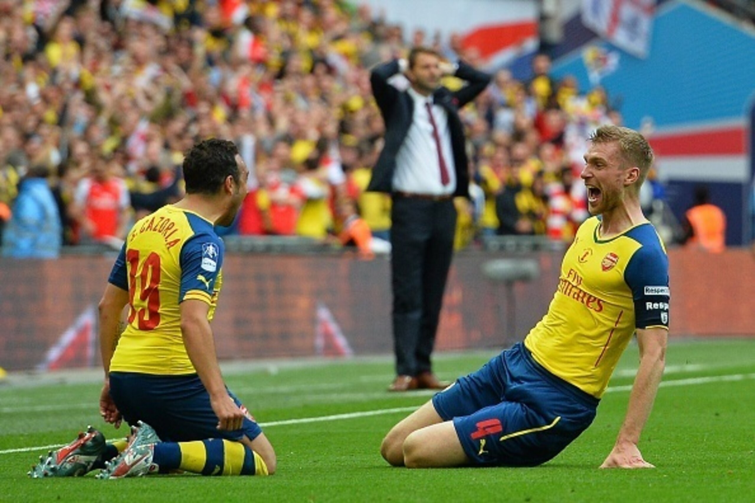 Arsenal's German defender Per Mertesacker (R) celebrates with Arsenal's Spanish midfielder Santi Cazorla after scoring their third goal during the FA Cup final football match between Aston Villa and Arsenal at Wembley stadium in London on May 30, 2015.   