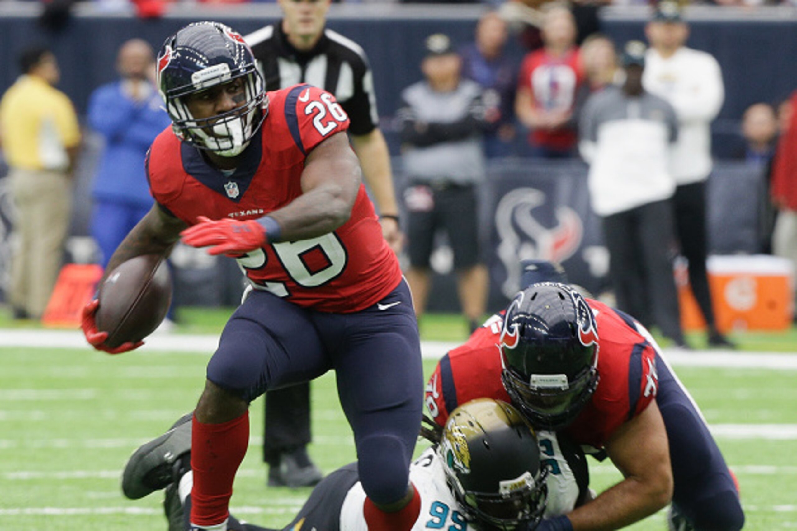 HOUSTON, TX - DECEMBER 18:  Lamar Miller #26 of the Houston Texans breaks a tackle attempt by Sen'Derrick Marks #99 of the Jacksonville Jaguars as Duane Brown #76 blocks on the play at NRG Stadium on December 18, 2016 in Houston, Texas.  (Photo by Bob Lev