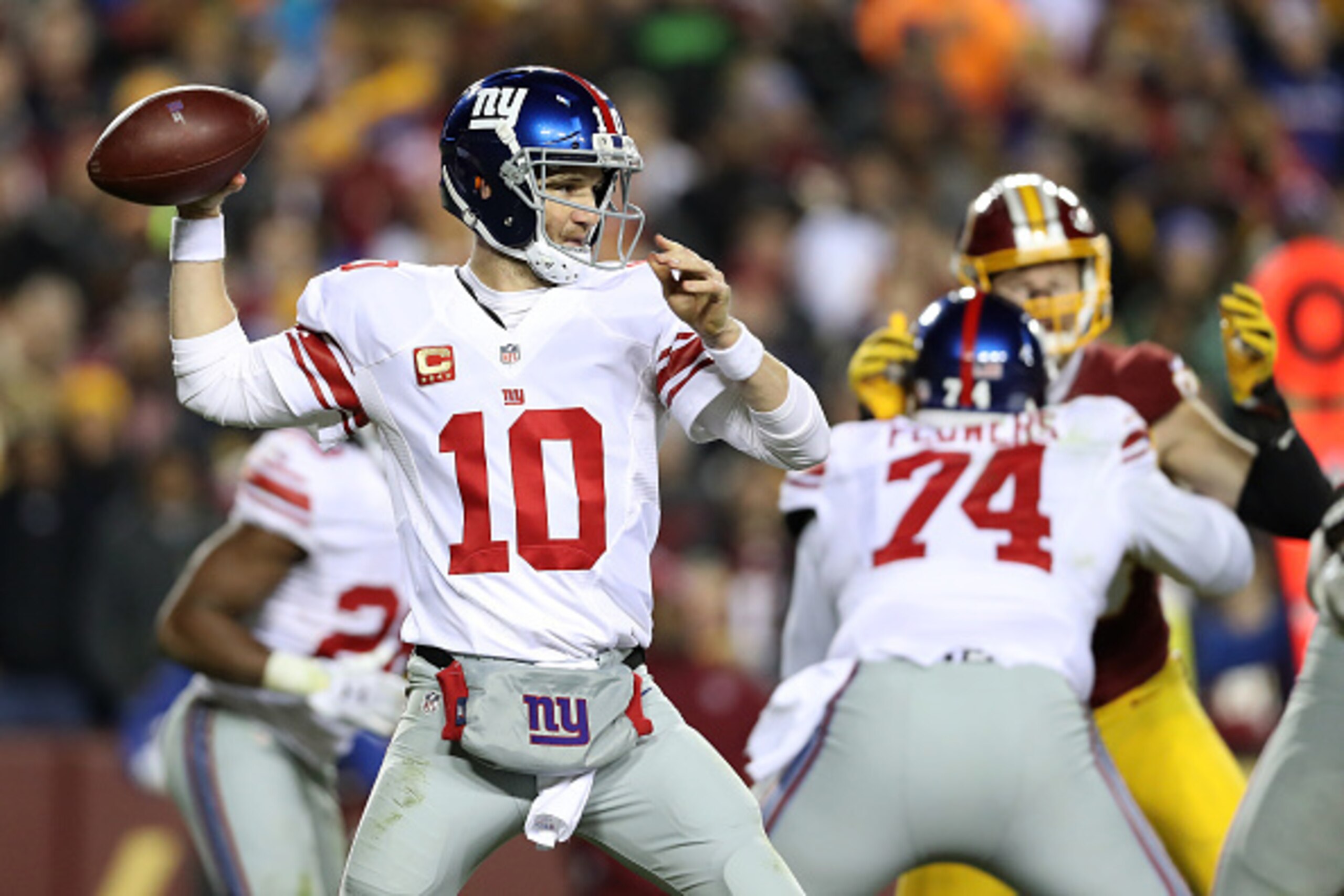 LANDOVER, MD - JANUARY 01: Quarterback Eli Manning #10 of the New York Giants passes the ball while teammate offensive tackle Ereck Flowers #74 blocks against the Washington Redskins in the fourth quarter at FedExField on January 1, 2017 in Landover, Mary