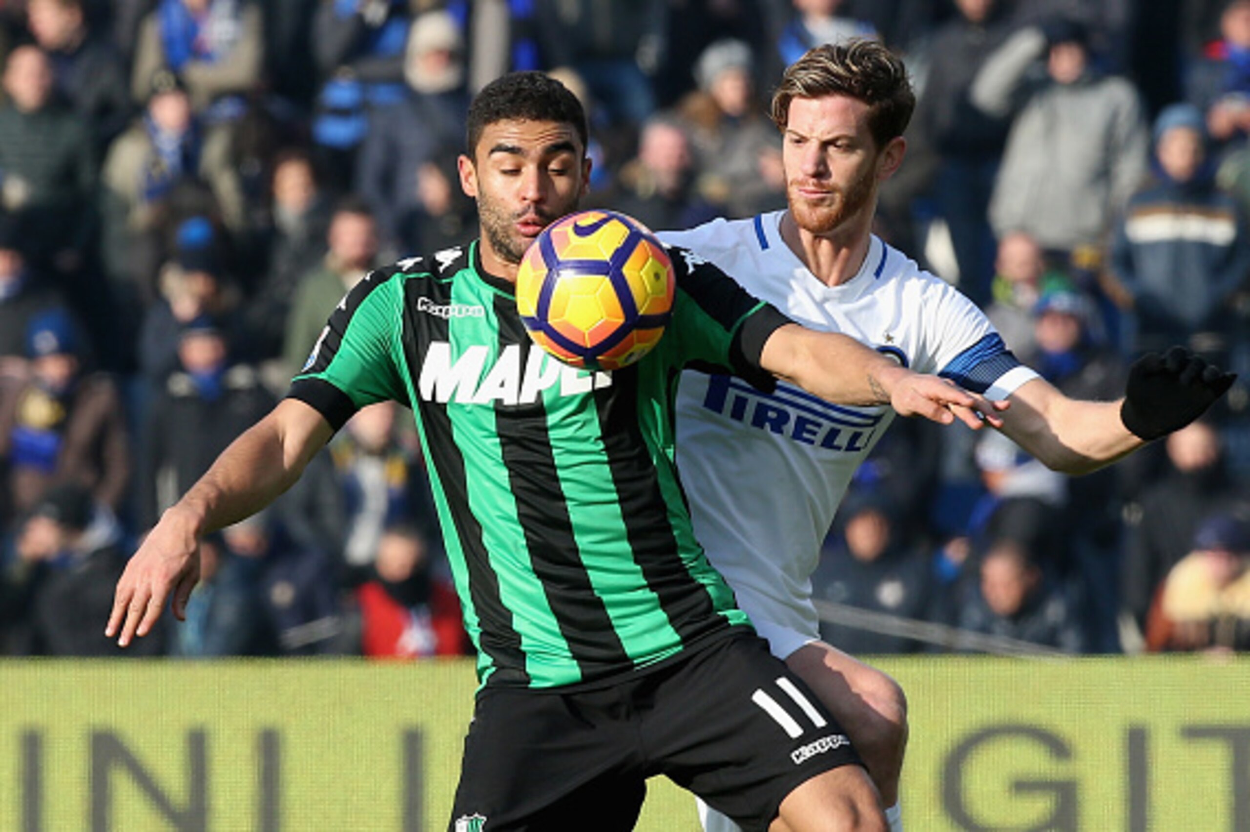 REGGIO NELL'EMILIA, ITALY - DECEMBER 18:  Gregoire Defrel (L) of Sassuolo competes for the ball with Cristian Ansaldi of Inter during the Serie A match between US Sassuolo and FC Internazionale at Mapei Stadium - Citta' del Tricolore on December 18, 2016 