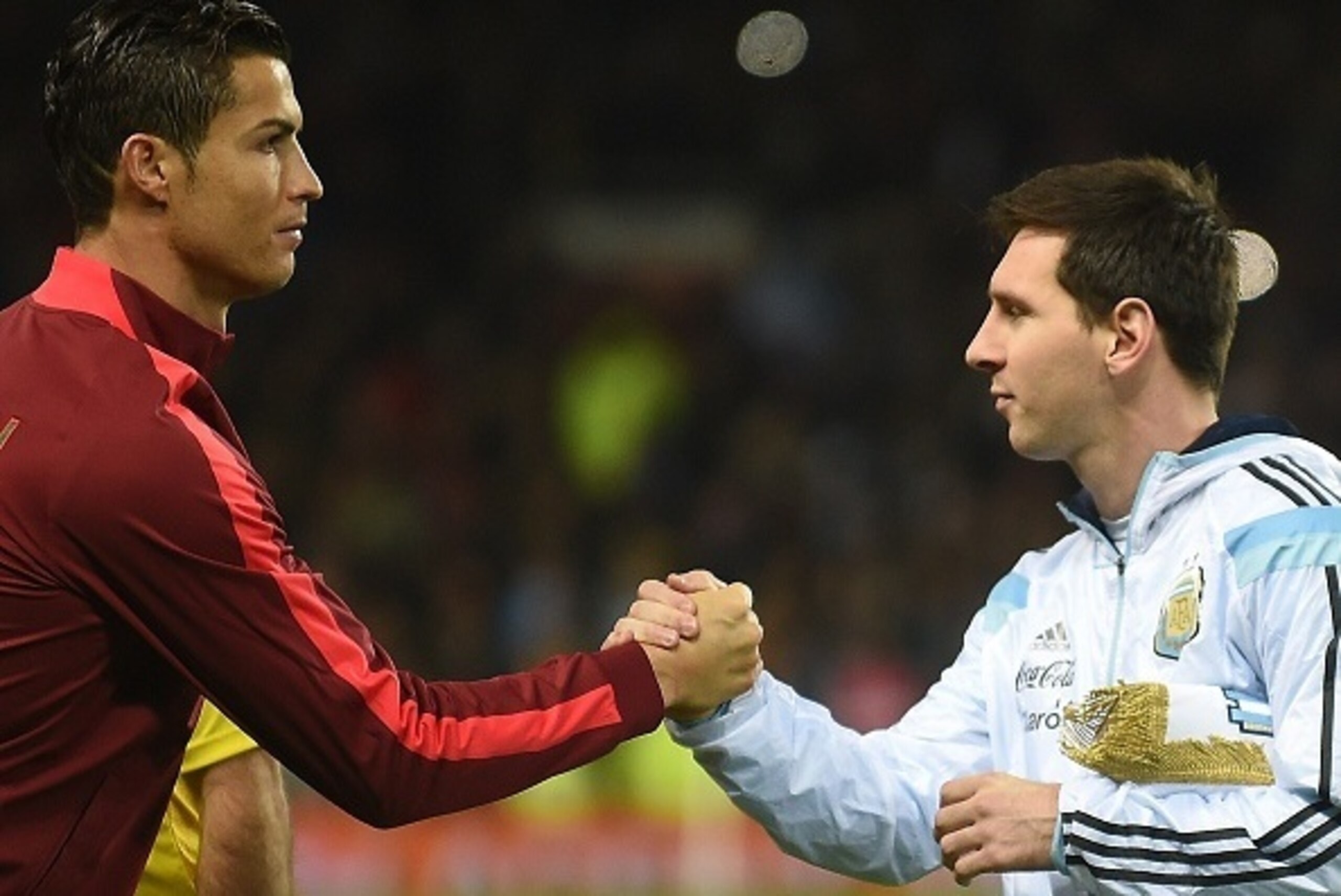 Argentina striker Lionel Messi (R) shakes hands with Portugal's striker Cristiano Ronaldo (L) ahead of kick off of the international friendly football match between the Argentina and Portugal at Old Trafford in Manchester on November 18, 2014. AFP PHOTO /
