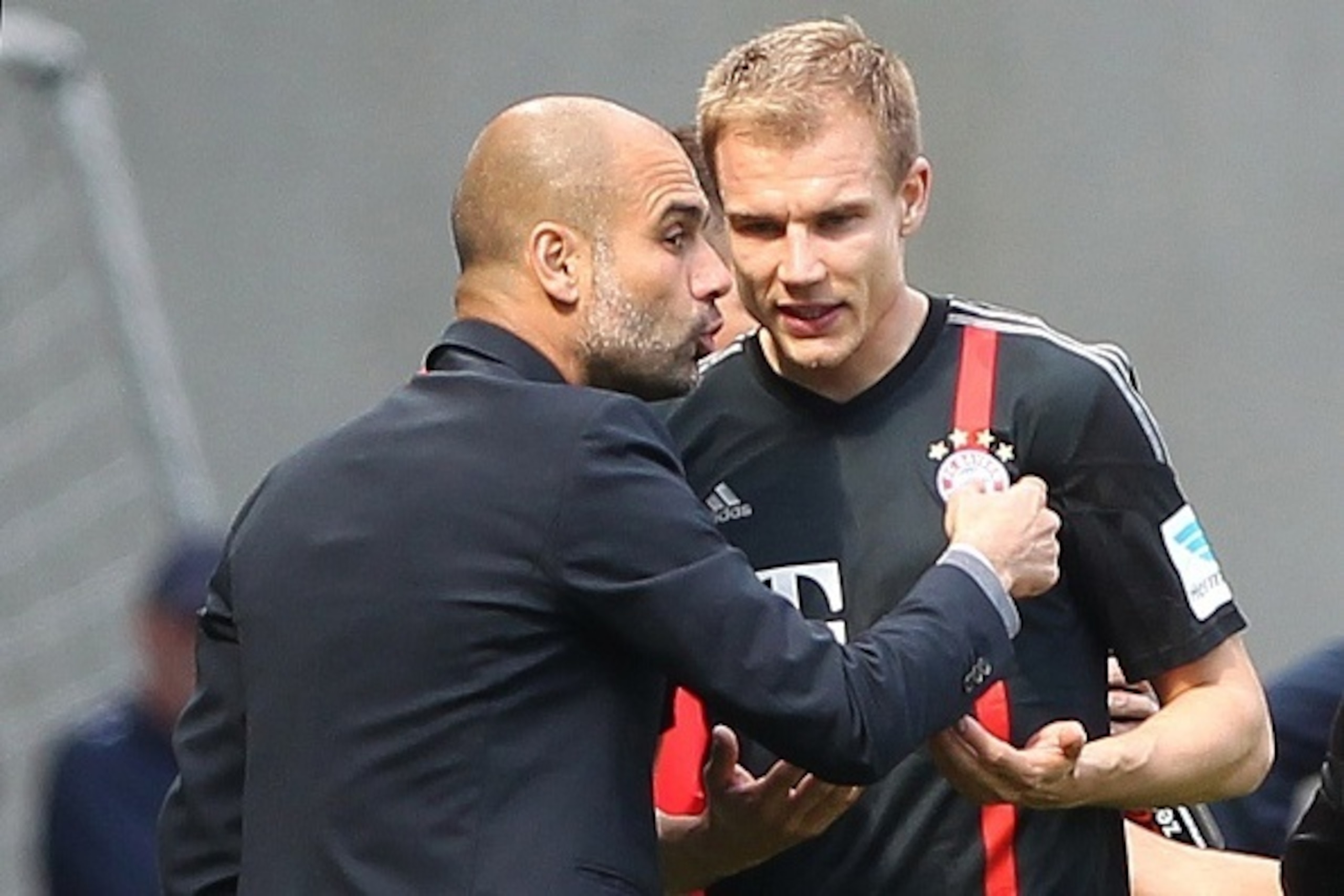 Bayern Munich's Spanish head coach Pep Guardiola (L) talks with Bayern Munich's defender Holger Badstuber during the German first division Bundesliga football match 1899 Hoffenheim vs FC Bayern Munich in Sinsheim, southern Germany, on April 18, 2015. AFP 