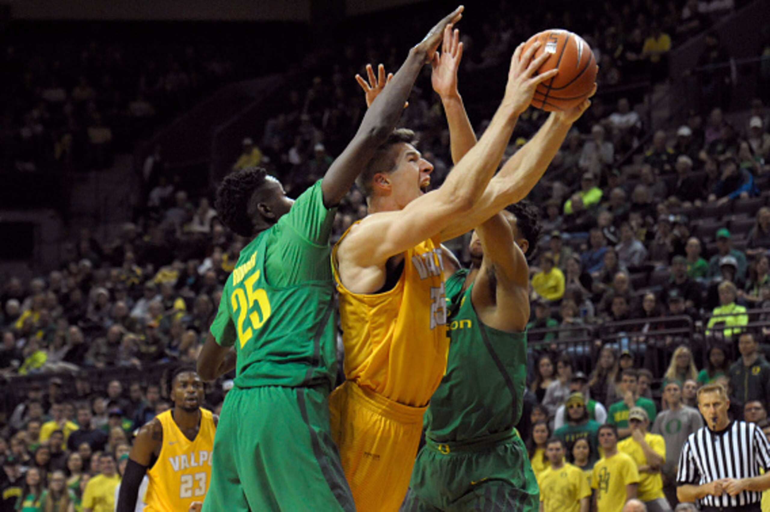 EUGENE, OR - NOVEMBER 17:  Alec Peters #25 of the Valparaiso Crusaders drives to the basket on Chris Boucher #25 and Keith Smith #11 of the Oregon Ducks in the second half of the game at Matthew Knight Arena on November 17, 2016 in Eugene, Oregon. Oregon 