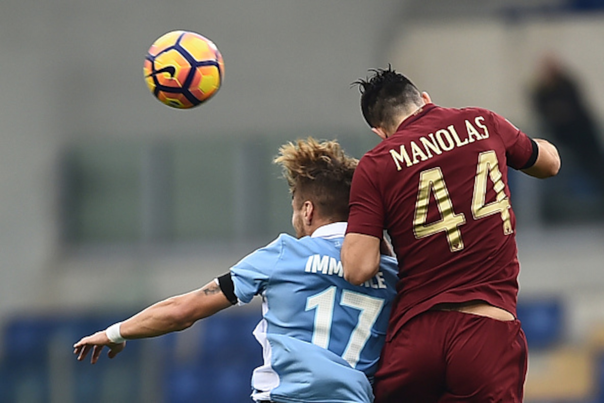 Lazio's forward from Italy Ciro Immobile (L) fights for the ball with Roma's defender from Greece Kostas Manolas during the Italian Serie A football match SS Lazio vs AS Roma on December 4, 2016 at the Olympic stadium in Rome.  / AFP / FILIPPO MONTEFORTE 