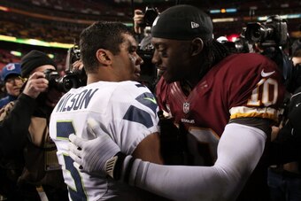 LANDOVER, MD - JANUARY 06:  Robert Griffin III #10 of the Washington Redskins embraces  Russell Wilson #3 of the Seattle Seahawks after the Seahawks defeated the Redskins 24 to 14 during the NFC Wild Card Playoff Game at FedExField on January 6, 2013 in L