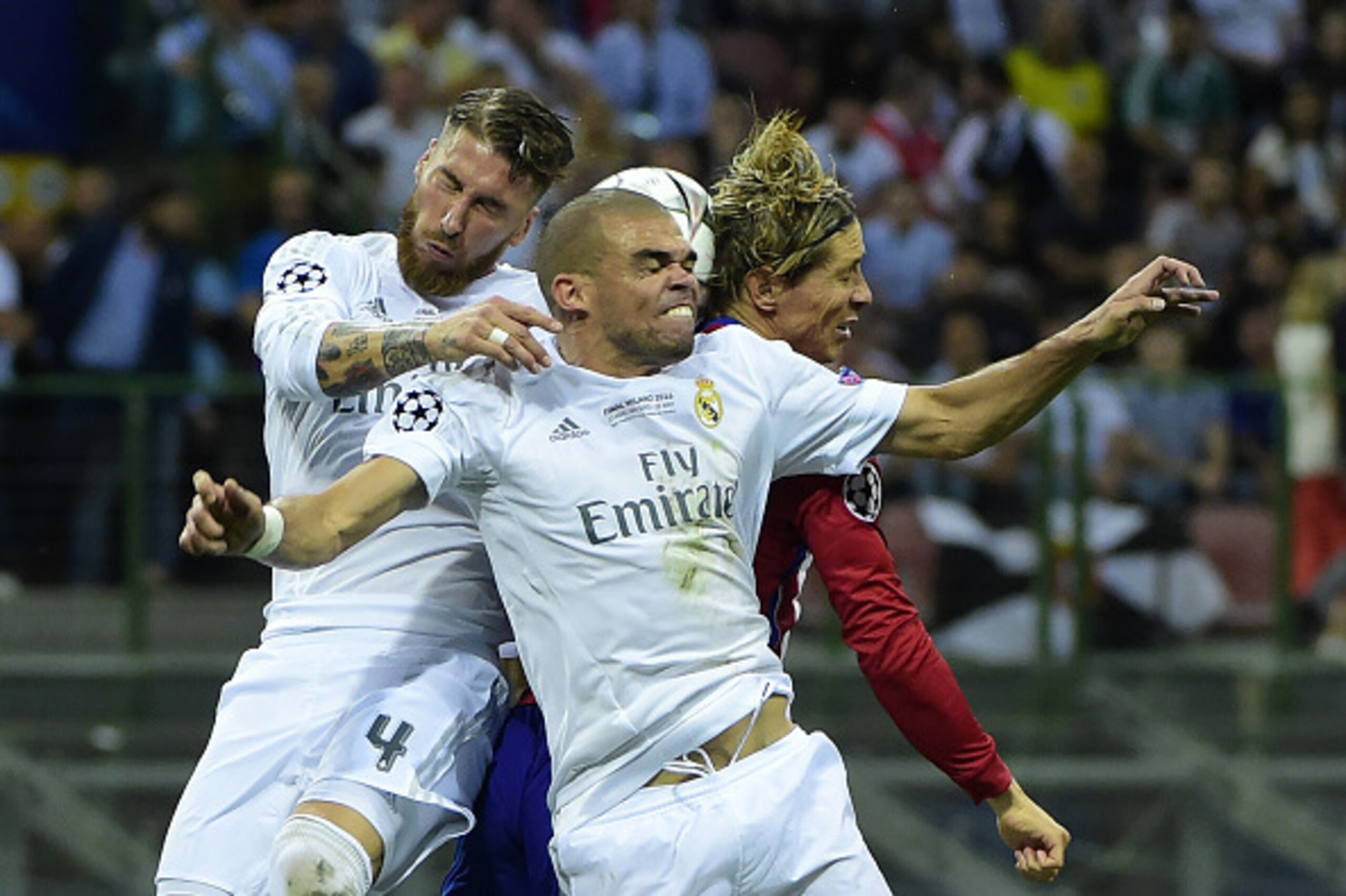 TOPSHOT - Real Madrid's Spanish defender Sergio Ramos (L), Real Madrid's Portuguese defender Pepe (C) and Atletico Madrid's Spanish forward Fernando Torres head the ball during the UEFA Champions League final football match between Real Madrid and Atletic
