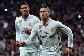Real Madrid's Colombian midfielder James Rodriguez (R) celebrates past Real Madrid's French defender Raphael Varane after scoring on a penalty kick during the Spanish Copa del Rey (King's Cup) round of 16 first leg football match Real Madrid CF vs Sevilla