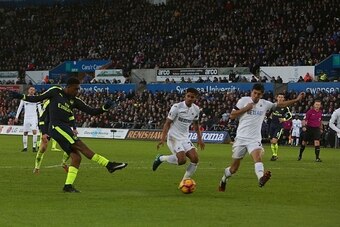 Arsenal's Nigerian striker Alex Iwobi (L) shoots, but has his shot deflected off of Swansea City's English midfielder Jack Cork, during the English Premier League football match between Swansea City and Arsenal at The Liberty Stadium in Swansea, south Wal Arsenal's Nigerian striker Alex Iwobi (L) shoots, but has his shot deflected off of Swansea City's English midfielder Jack Cork, during the English Premier League football match between Swansea City and Arsenal at The Liberty Stadium in Swansea, south Wal