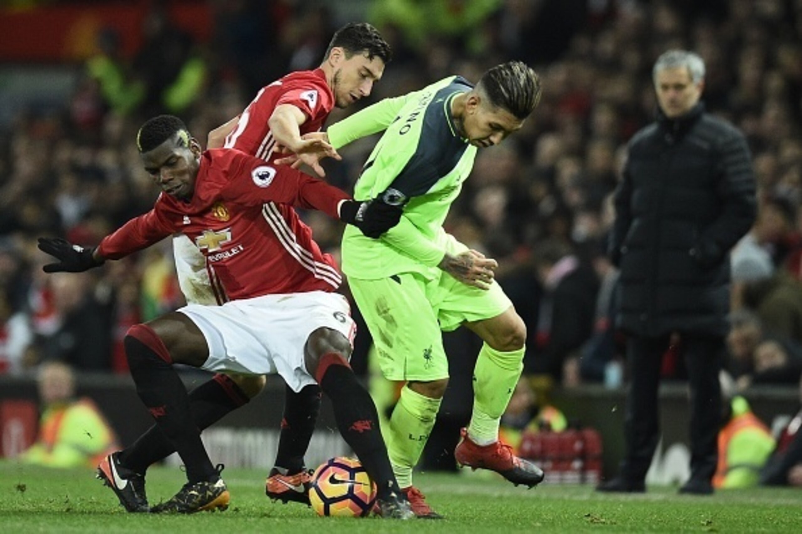 Manchester United's French midfielder Paul Pogba (L) vies with Liverpool's Brazilian midfielder Roberto Firmino (C) as Manchester United's Portuguese manager Jose Mourinho (R) looks on during the English Premier League football match between Manchester Un Manchester United's French midfielder Paul Pogba (L) vies with Liverpool's Brazilian midfielder Roberto Firmino (C) as Manchester United's Portuguese manager Jose Mourinho (R) looks on during the English Premier League football match between Manchester Un