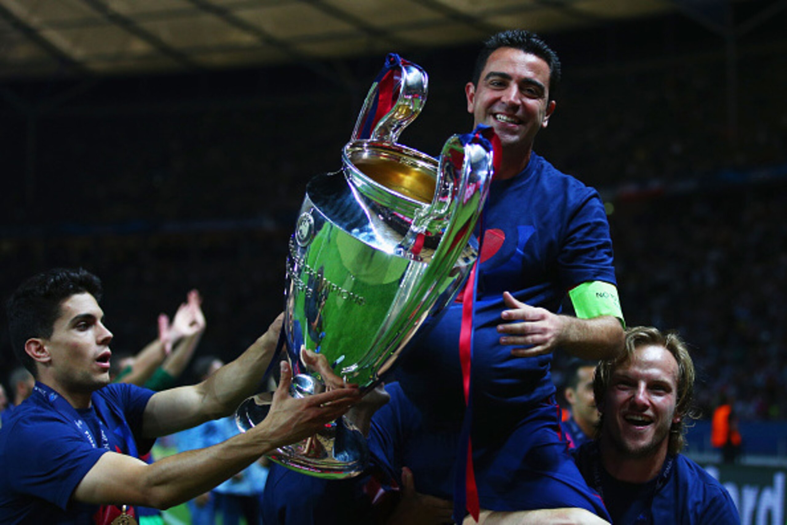 BERLIN, GERMANY - JUNE 06: Xavi Hernandez of Barcelona celebrates with Ivan Rakitic (R) and the trophy after the UEFA Champions League Final between Juventus and FC Barcelona at Olympiastadion on June 6, 2015 in Berlin, Germany.  (Photo by Paul Gilham/Get
