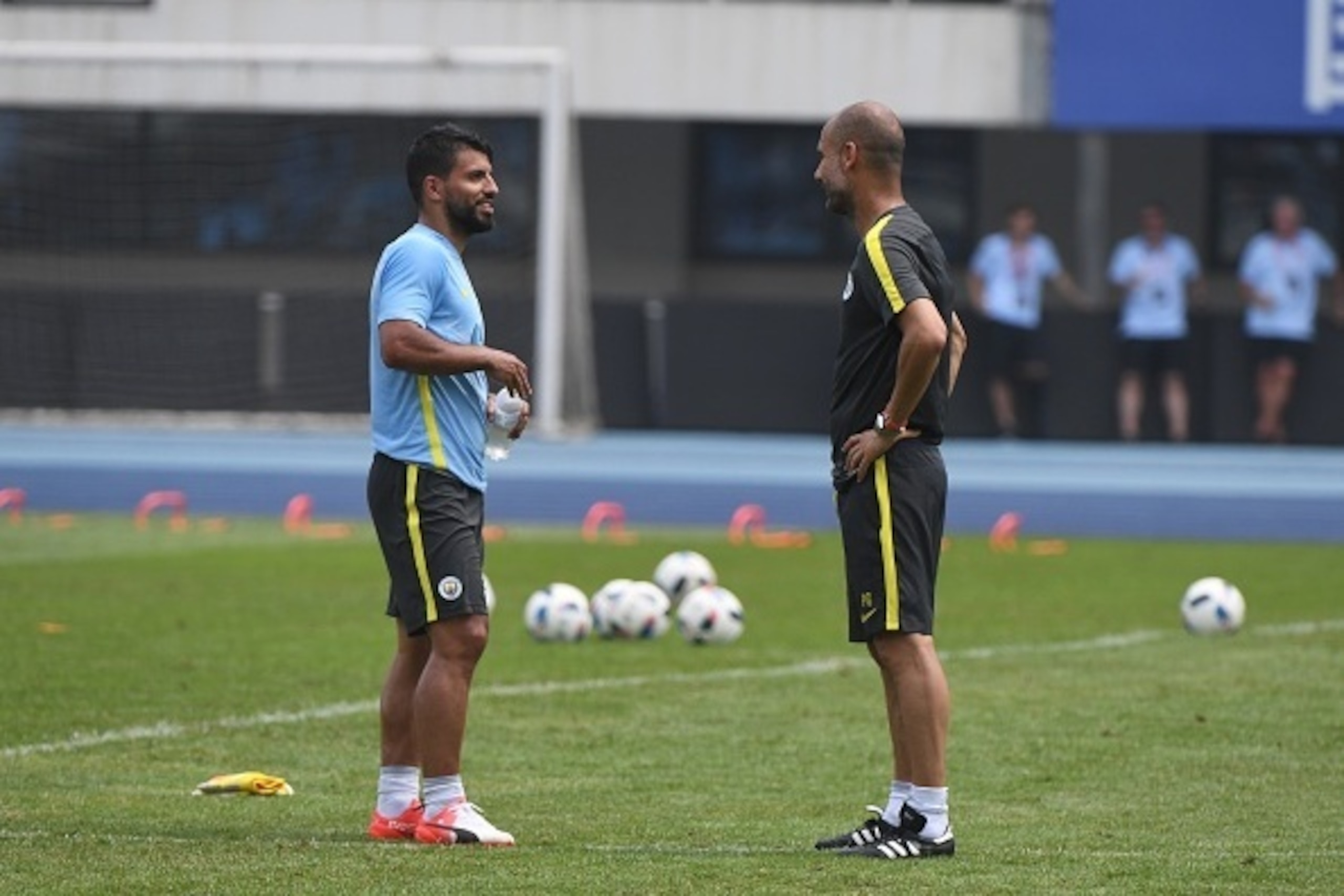 Manchester City's Sergio Aguero (L) chats with coach Pep Guardiola during a training session a day before the 2016 International Champions Cup football match between Manchester City and Manchester United, in Beijing on July 24, 2016. / AFP / GREG BAKER   