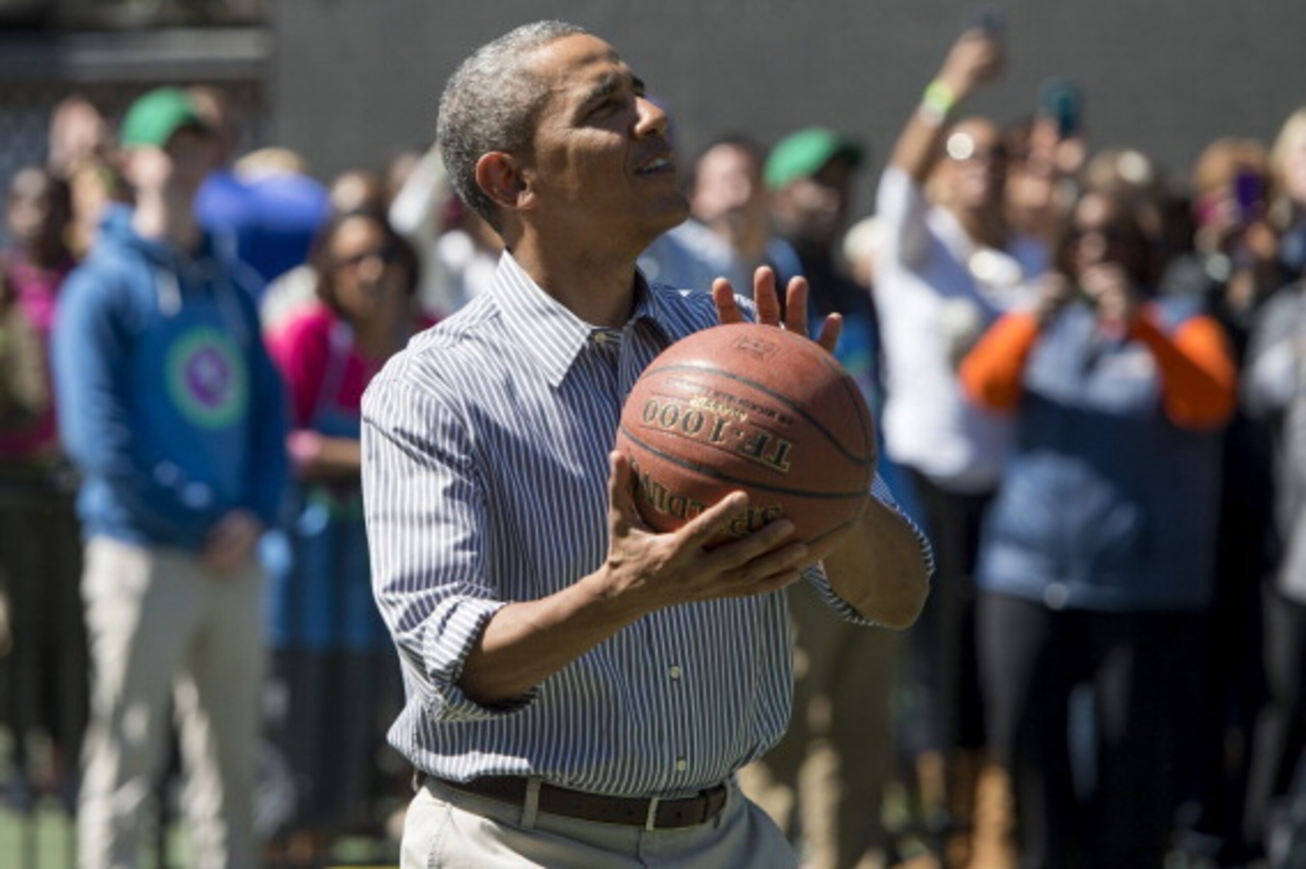 US President Barack Obama shoots a basketball during the annual White House Easter Egg Roll on the South Lawn of the White House in Washington, DC, April 21, 2014. The 126th annual White House Easter Egg Roll, the largest annual public event at the White 