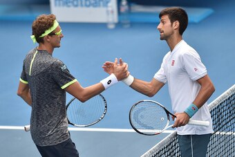 Serbia's Novak Djokovic (R) shakes hands with Uzbekistan's Denis Istomin after defeat during their men's singles second round match on day four of the Australian Open tennis tournament in Melbourne on January 19, 2017. / AFP / PETER PARKS / IMAGE RESTRICT