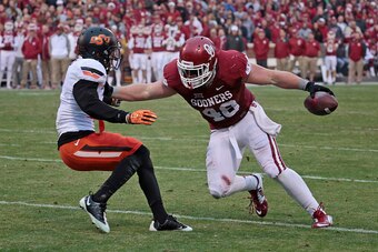 NORMAN, OK - DECEMBER 6:  Fullback Aaron Ripkowski #48 of the Oklahoma Sooners tries to get around cornerback Kevin Peterson #1 of the Oklahoma State Cowboys December 6, 2014 at Gaylord Family-Oklahoma Memorial Stadium in Norman, Oklahoma. The Cowboys def