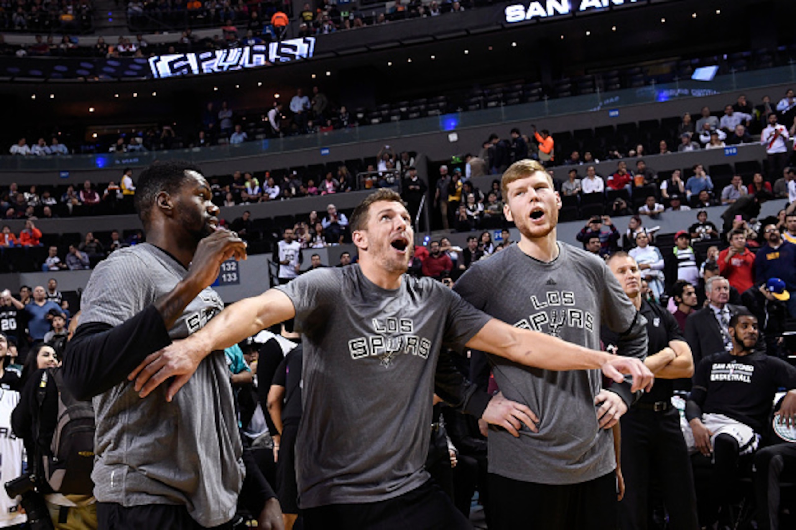 MEXICO CITY, MEXICO - JANUARY 14:  Dewayne Dedmon #3, David Lee #10 and Davis Bertans #42 of the San Antonio Spurs react to a play in warm ups before the game against the Phoenix Suns as part of NBA Global Games at Arena Ciudad de Mexico on January 14, 20