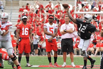 COLUMBUS, OH - APRIL 18:  Quarterbacks J.T. Barrett #16 of the Ohio State Buckeyes and Braxton Miller #5 of the Ohio State Buckeyes watch alongside Head Coach Urban Meyer of the Ohio State Buckeyes as Cardale Jones #12 of the Ohio State Buckeyes runs the 